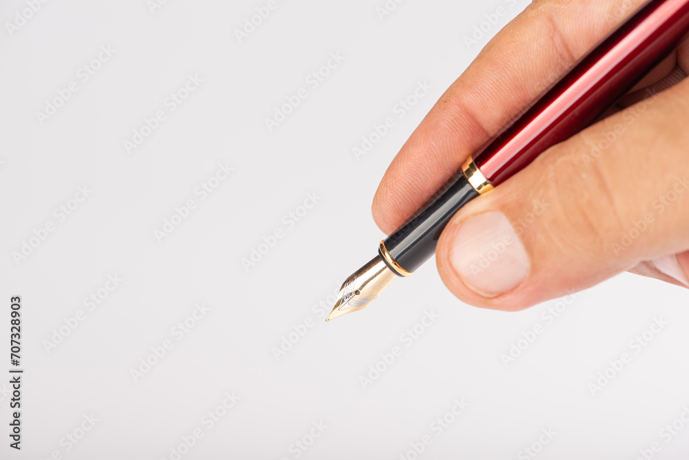 Fountain pen and hand, beautiful fountain pen in detail held in hand, with white background, selective focus. Fountain pen and hand, beautiful fountain pen in detail held in hand, with white background, selective focus.