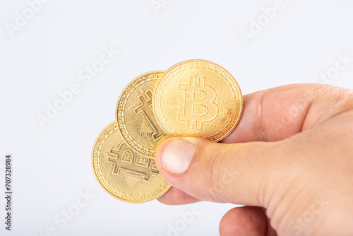 Bitcoin, hand holding bitcoin coins, with white background, selective focus.
