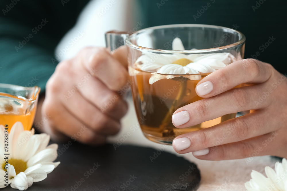 Female hands with cup of tea, honey and beautiful chrysanthemums on white table Female hands with cup of tea, honey and beautiful chrysanthemums on white table