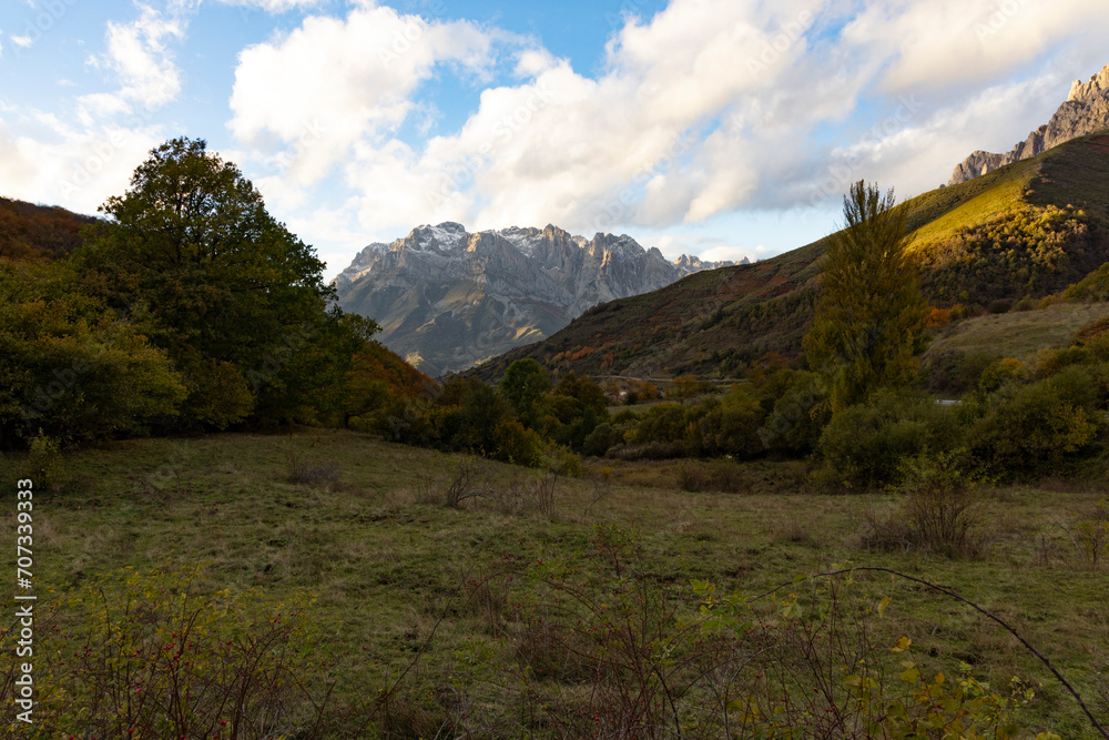 Landscape of Picos de Europa mountains in Spain at sunset with autumn forest leaves