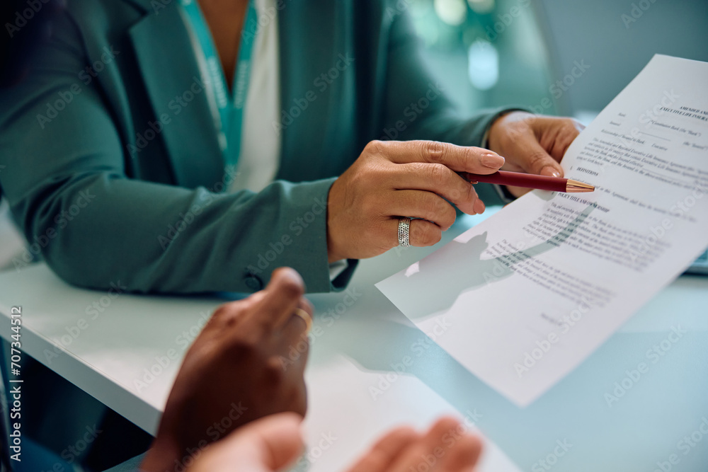 Close up of financial advisor going through contract with couple during meeting. Close up of financial advisor going through contract with couple during meeting.