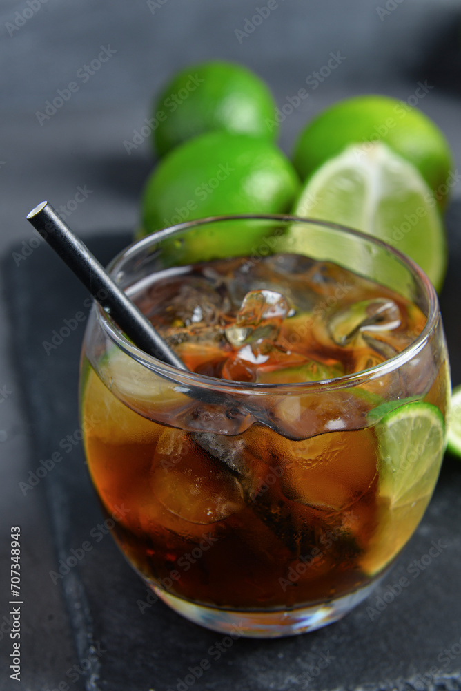Glass of cold Cuba Libre cocktail on grey background Glass of cold Cuba Libre cocktail on grey background