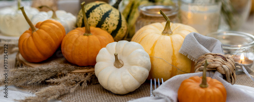 Fall still-life. Orange pumpkins, dry flowers and candles on linen tablecloth. Dinner table outdoors in the garden. Cozy autumn concept., simple handmade decoration, countryside style banner