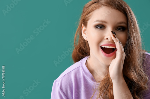 Young gossip woman on green background, closeup photo