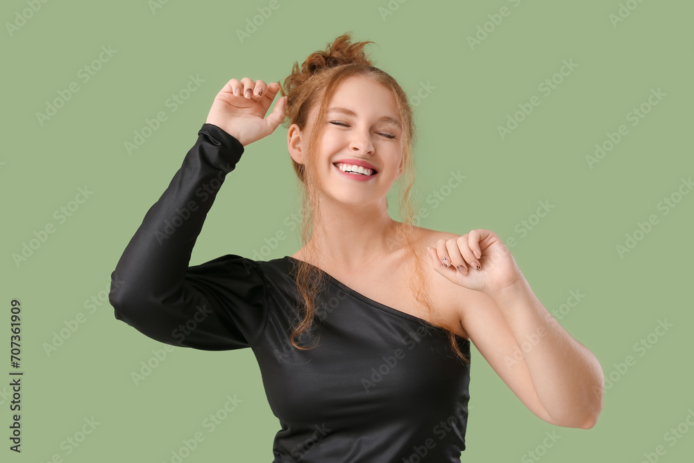 Portrait of happy redhead woman celebrating success on green background Portrait of happy redhead woman celebrating success on green background