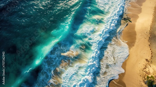  a bird's eye view of a beach with a wave coming in to the shore and a person standing on a surfboard in the middle of the water.
