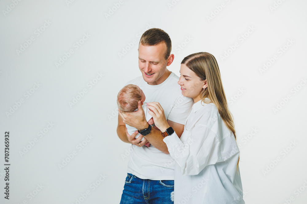 Loving mom and dad are holding a newborn baby in their arms. Father and mother and his cute newborn son. Parental relationship between parents and son. Happy parenthood and the joy of being parents Loving mom and dad are holding a newborn baby in their arms. Father and mother and his cute newborn son. Parental relationship between parents and son. Happy parenthood and the joy of being parents