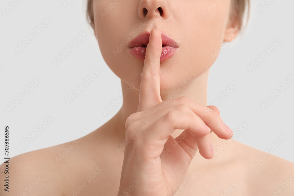 Beautiful young woman showing silence gesture on white background Beautiful young woman showing silence gesture on white background
