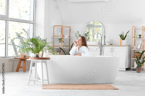 Beautiful woman near bathtub at home