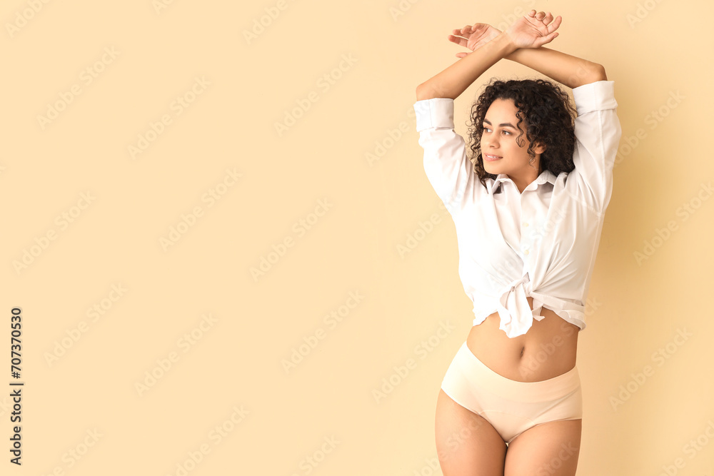 Young African-American woman in menstrual panties on beige background - obrazy, fototapety, plakaty 