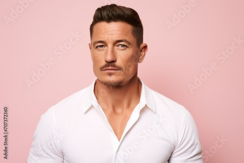 Portrait of handsome man in white shirt, isolated over pink background © Inigo