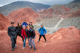 Grupo de amigos en la cumbre de un cerro colorado en Purmamarca, Argentina