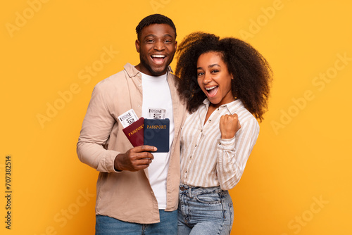 Joyful black couple with passports ready to travel