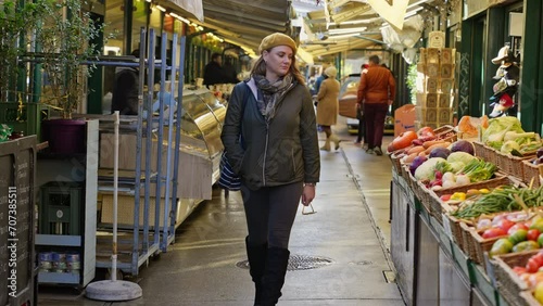 Person walking next to food booths in an open air markets on a cold day, Vienna, Austria