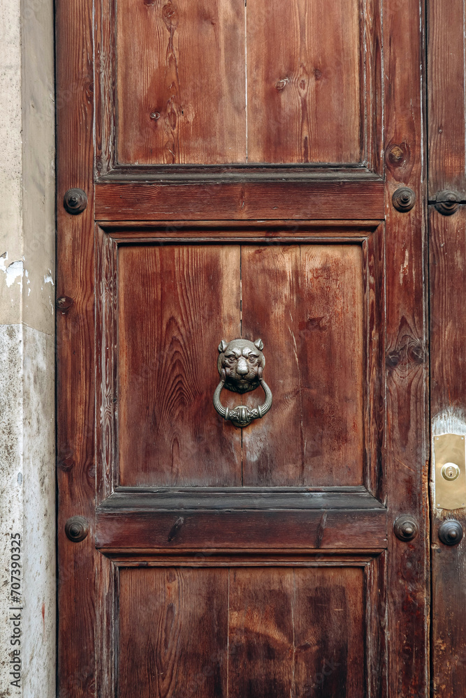 Beautiful door handle on an antique wooden door in Rome