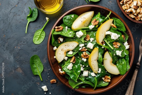 Top view of Pear and Spinach Salad with Walnuts and Feta