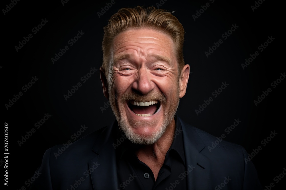Portrait of a senior man laughing against a dark background. Studio shot. Portrait of a senior man laughing against a dark background. Studio shot.
