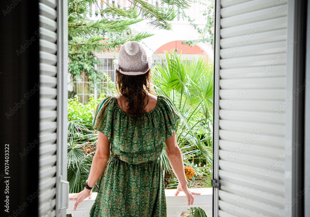 woman enjoying lush greenery in front of hotel room