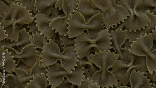 Italian green farfalle pasta background. Table spin. photo