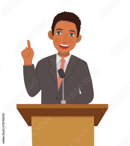 Young African man speaker giving speech standing at podium in a conference meeting hall
