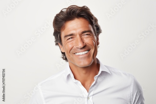 Handsome smiling man in white shirt. Isolated on white background. © Inigo