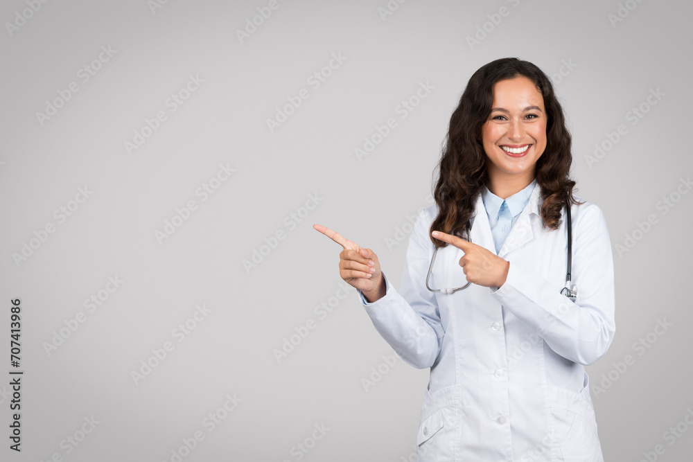 Doctor pointing sideways at free space with bright smile Doctor pointing sideways at free space with bright smile