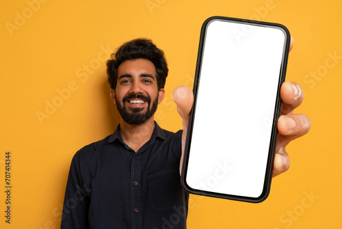 Cheerful Indian Man Showing Big Phone With White Blank Screen photo