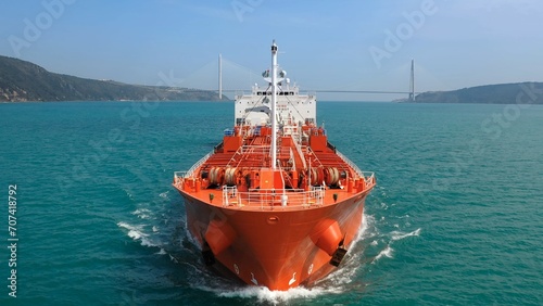 Supertanker loaded with crude oil sails towards the camera at full speed in the Bosphorus Sea. Red prow, bow, front deck, pipe lines and winches of oil products tanker underways ocean. Aerial Drone
