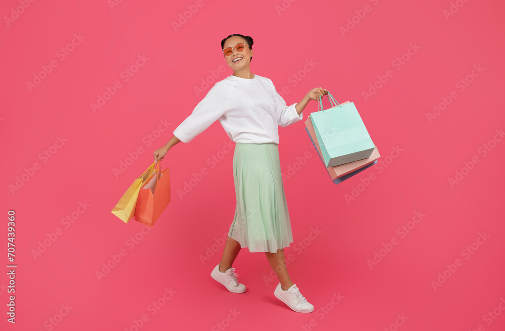 Seasonal Sales Concept. Smiling Asian Woman Walking With Shopping Bags Seasonal Sales Concept. Smiling Asian Woman Walking With Shopping Bags