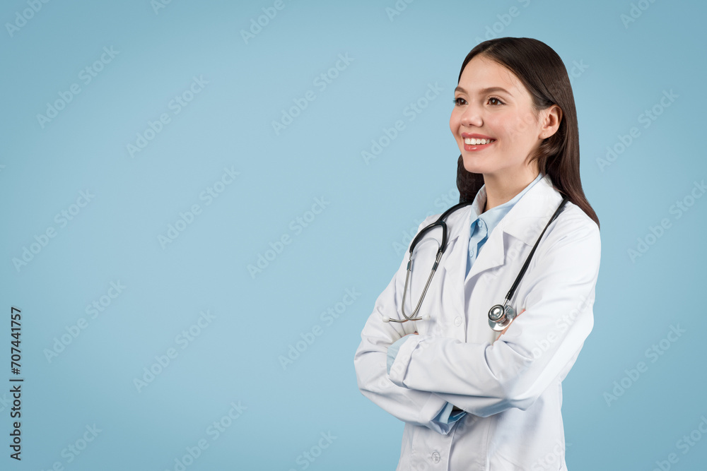 Happy young doctor with stethoscope over blue background, copy space Happy young doctor with stethoscope over blue background, copy space