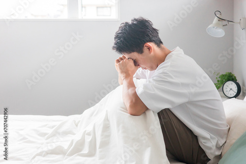 ベッドルームでストレス・風邪・鬱病・疲労・出社拒否に悩む男性（体調不良）
 photo