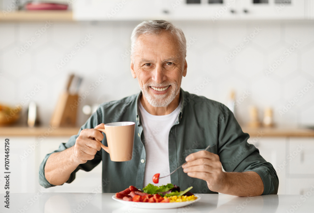 Smiling elderly man eating lunch and enjoying cup of coffee Smiling elderly man eating lunch and enjoying cup of coffee