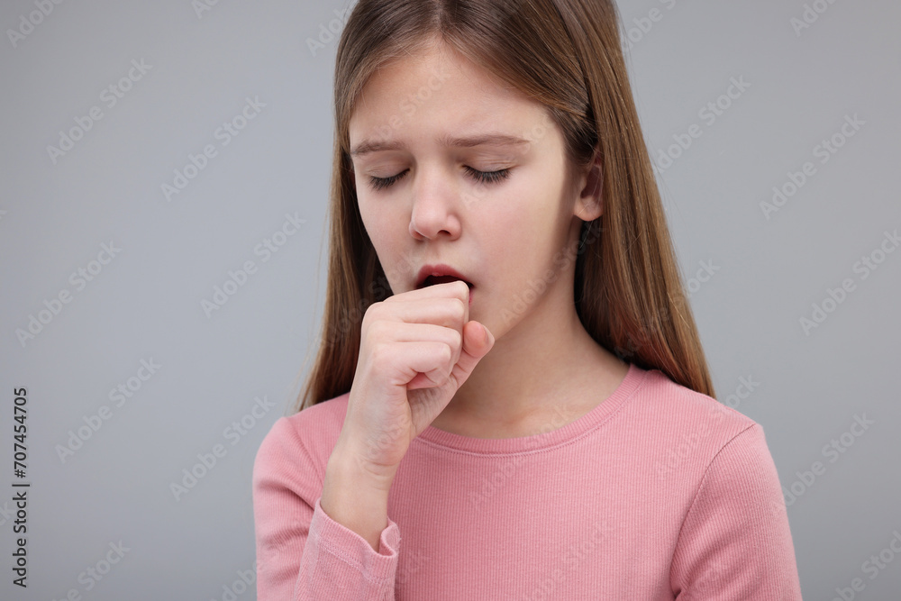 Sick girl coughing on gray background. Cold symptoms Sick girl coughing on gray background. Cold symptoms