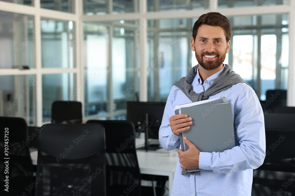 Fototapeta premium Happy man with folders in office, space for text