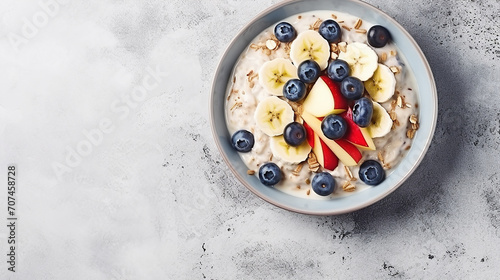 bircher muesli or overnight oatmeal with apple banana blueberry on white marble table