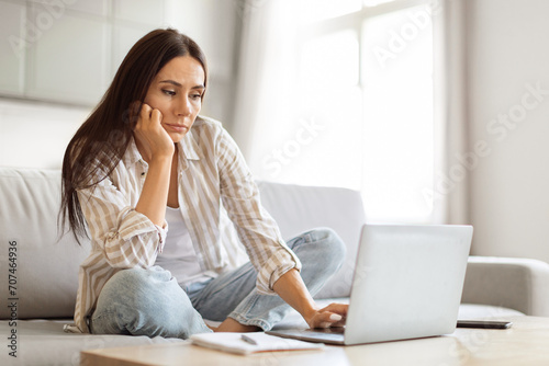 Canvastavla Upset Young Woman Looking At Laptop Screen While Working At Home Office