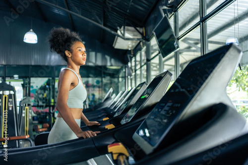 African American young sportswoman exercise by run on treadmill in gym.