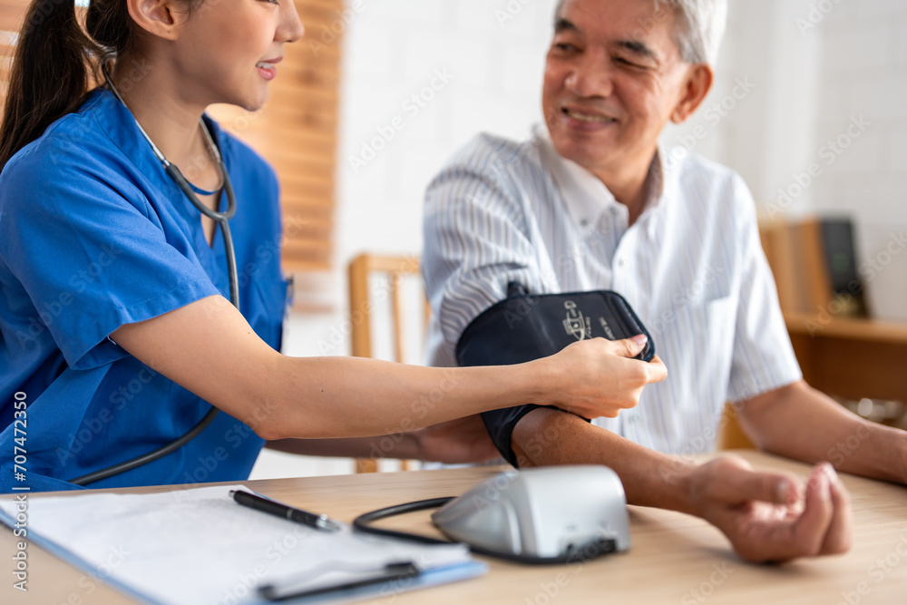 Asian caregiver doctor examine older patient use blood pressure gauge. Asian caregiver doctor examine older patient use blood pressure gauge.