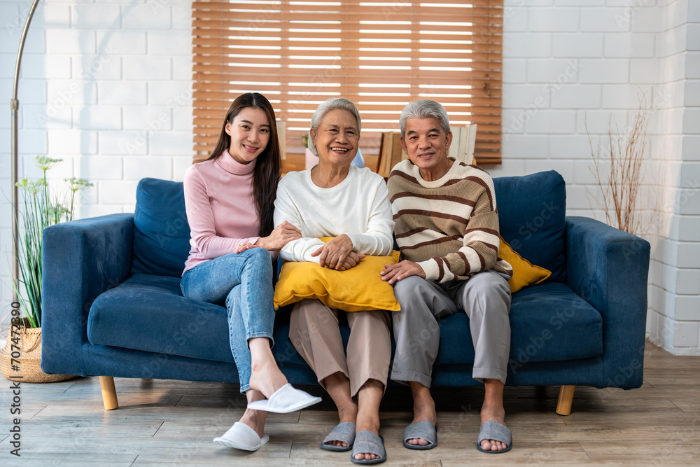 Portrait of Asian senior couple sitting on sofa with daughter in house. Portrait of Asian senior couple sitting on sofa with daughter in house.