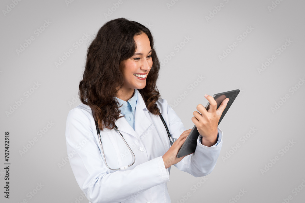 Doctor woman using tablet with friendly expression Doctor woman using tablet with friendly expression
