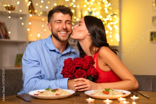 Happy couple at dinner, woman kissing man's cheek