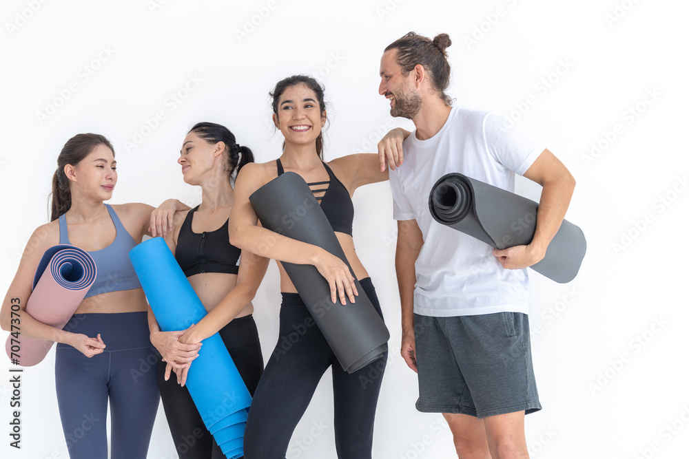 Obraz premium Group of happy sporty women talking with body stylish sportswear holding personal carpets leaned on a white background. waiting for yoga class or body weight class. healthy lifestyle and wellness