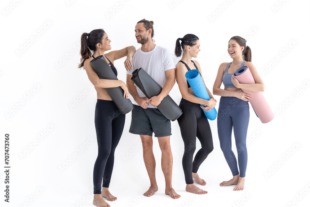 Fototapeta premium Group of happy sporty girls and guy wearing body stylish sportswear holding personal carpets leaned on a white background. waiting for yoga class or body weight class. healthy lifestyle and wellness