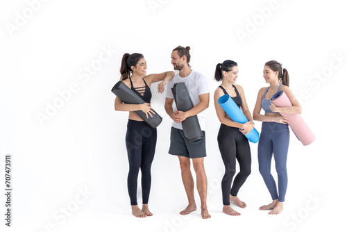 Group of happy sporty girls and guy wearing body stylish sportswear holding personal carpets leaned on a white background. waiting for yoga class or body weight class. healthy lifestyle and wellness