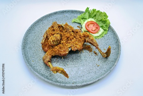 Ayam Goreng Lengkuas Kremes or Galangal Fried Chicken, One of Indonesia's culinary icons from the city of Bandung. This fried chicken sprinkled with serundeng comes from grated galangal. photo