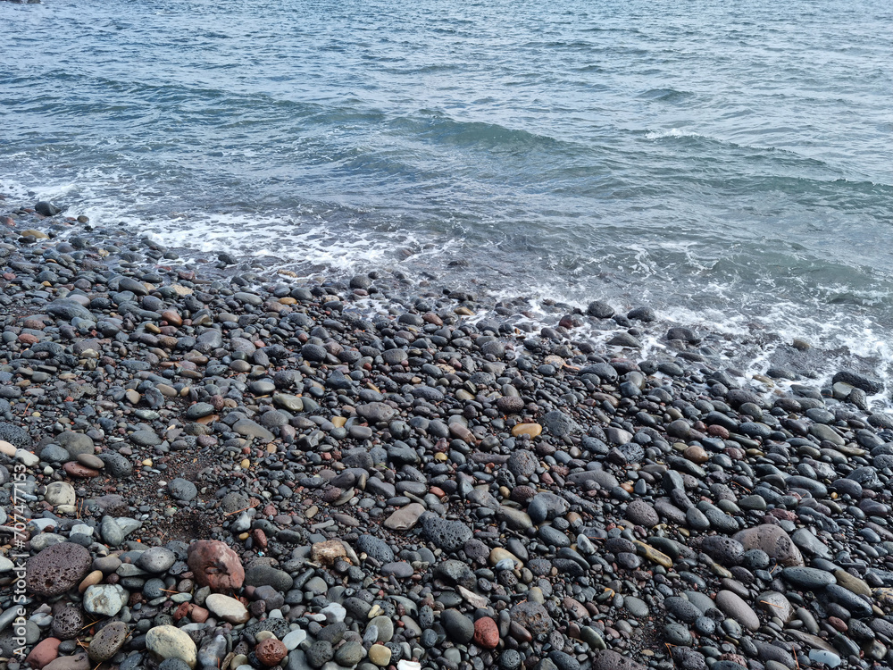 Jeju Island beach with round basalt rocks.
Jeju Island beach with round basalt rocks.