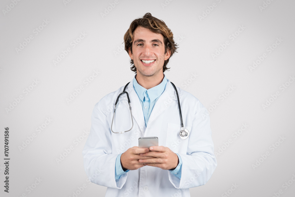 Smiling doctor using smartphone for healthcare apps Smiling doctor using smartphone for healthcare apps