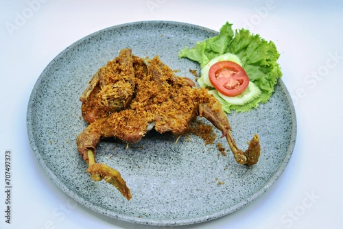 Ayam Goreng Lengkuas Kremes or Galangal Fried Chicken, One of Indonesia's culinary icons from the city of Bandung. This fried chicken sprinkled with serundeng comes from grated galangal. photo