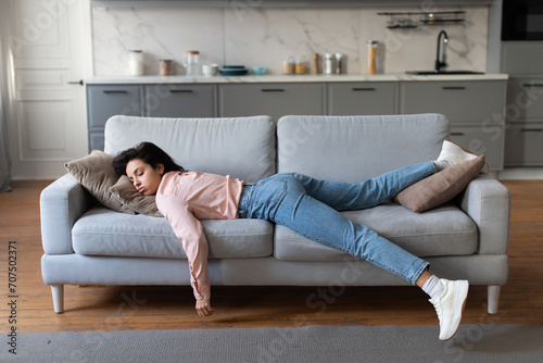 Fotografi Tired woman resting on sofa after housework