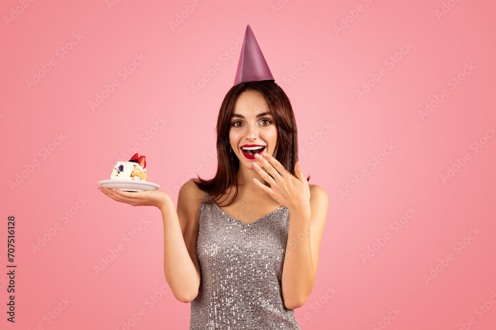 Happy millennial caucasian brunette woman in party cap, dress make wish Happy millennial caucasian brunette woman in party cap, dress make wish